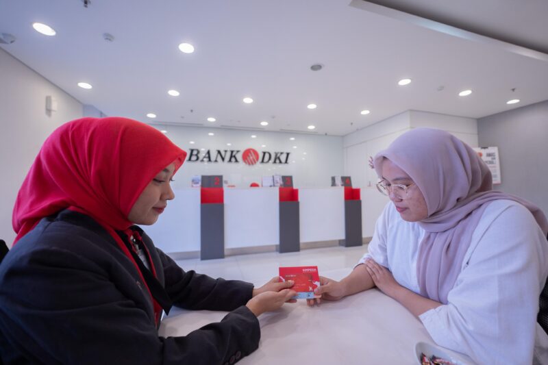 Keterangan Foto : Salah satu pegawai bank DKI sedang menunjukan kartu ATM Bank DKI ke nasabah Bank DKI/Doc/Ist