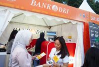 Keterangan Photo : Salah satu custemer Bank DKI memperkenalkan kartu pembayaran JakCard dan kartu JakMob ke salah satu pengunjung/Istimewa