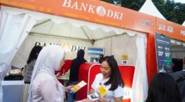 Keterangan Photo : Salah satu custemer Bank DKI memperkenalkan kartu pembayaran JakCard dan kartu JakMob ke salah satu pengunjung/Istimewa